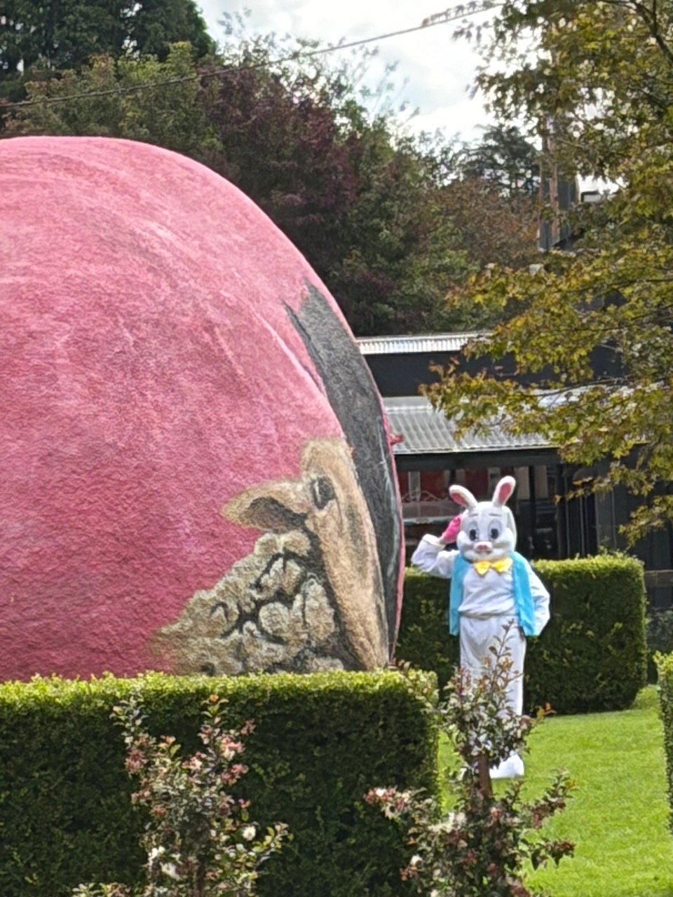 A large painted Easter egg sculpture and an Easter bunny mascot outside a shop in Kangaroo Valley.