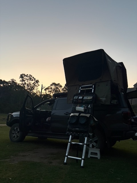 Roger the Ranger with the rooftop tent open, silhouetted against a fading dusk sky at Coorongooba.